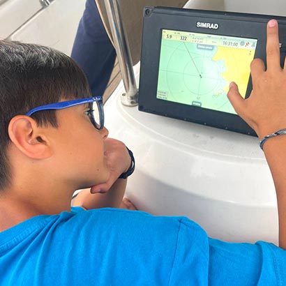 Un ragazzo esamina una carta nautica digitale